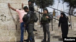 Polisi Israel memeriksa seorang pemuda Palestina sebelum memasuki kota tua Yerusalem untuk melakukan shalat Jumat (23/10).