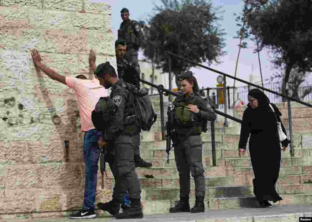 Israeli border policemen perform a security check on a Palestinian youth at Damascus Gate, outside Jerusalem&#39;s Old City before Friday prayers, Oct.&nbsp; 23, 2015.