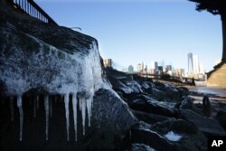 Ice forms on rocks on the Brooklyn waterfront across from lower Manhattan in New York, Jan. 7, 2014. The high temperature is expected to be 10 degrees in the city but wind chills will make it feel more like minus 10.