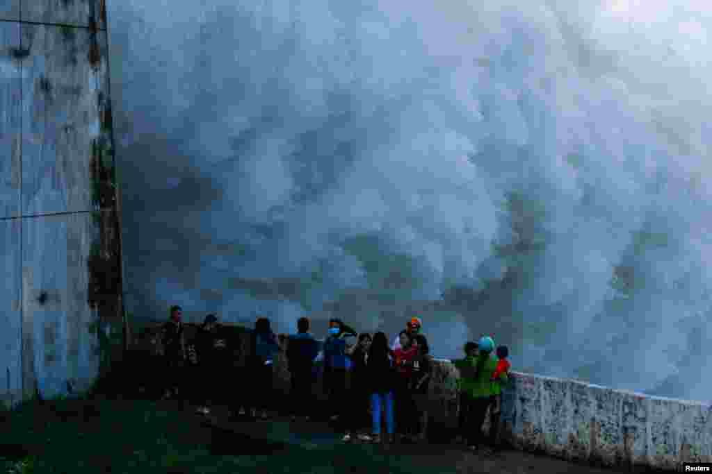 People watch as the the Hoa Binh hydroelectric power plant's flood gates are opened after a heavy rainfall caused by a tropical depression in Hoa Binh province outside Hanoi, Vietnam.