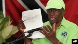 Former FIFA Vice President Jack Warner holds a copy of a check while he speaks at a political rally in Marabella, Trinidad and Tobago, June 3, 2015. 