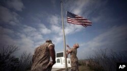 U.S. Marines hoist the U.S. flag on the summit of Mount Suribachi, near the site of a ceremony commemorating the 70th anniversary of the Battle of Iwo Jima, now known as Ioto, Japan, March 21, 2015.