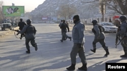 Afghan police officers run to the Kabul traffic police headquarters as it is attacked by insurgents in Kabul, January 21, 2013. 