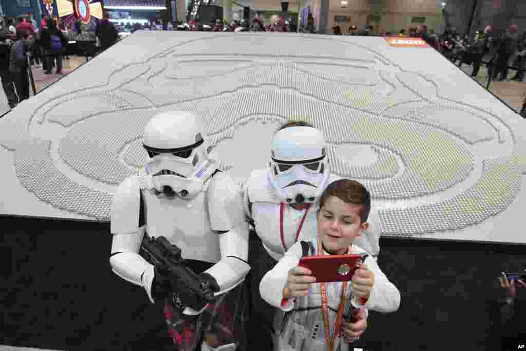 Star Wars enthusiast Joseph Naiman, 7, takes a selfie with his parents Marshall (L), and Danelle next to the largest display of LEGO Star Wars minifigures at Star Wars Celebration, April 11, 2019 in Chicago. The display, made up of 36,440 LEGO stormtrooper minifigures, broke the Guinness World Records title. (The LEGO Group)