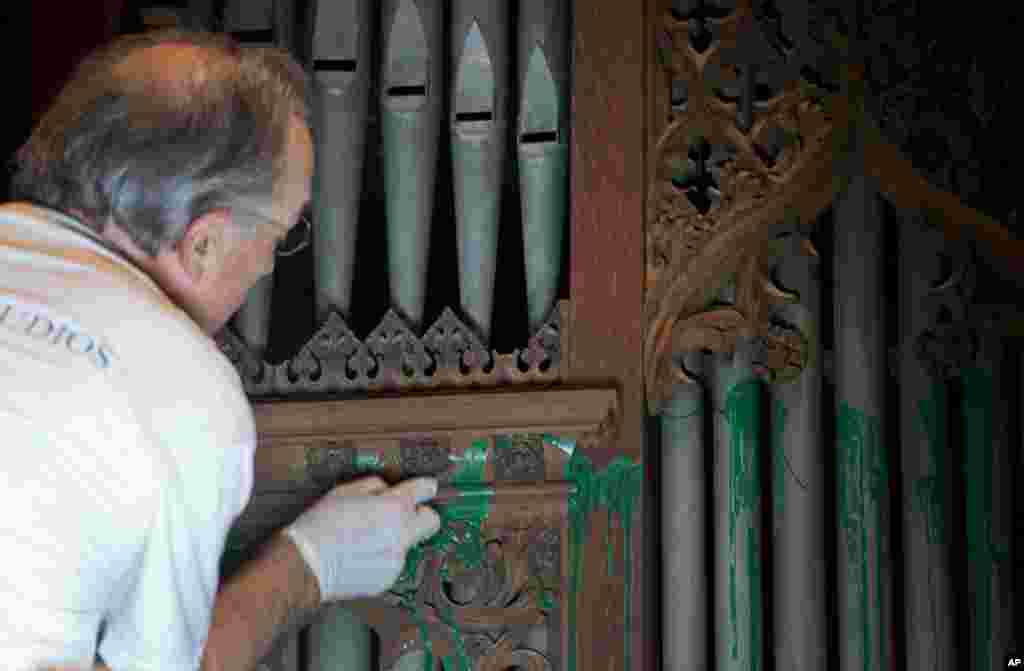 William Adair of Gold Leaf Studios removes green paint from the organ in the Washington National Cathedral's historic Bethlehem Chapel, July 30, 2013.