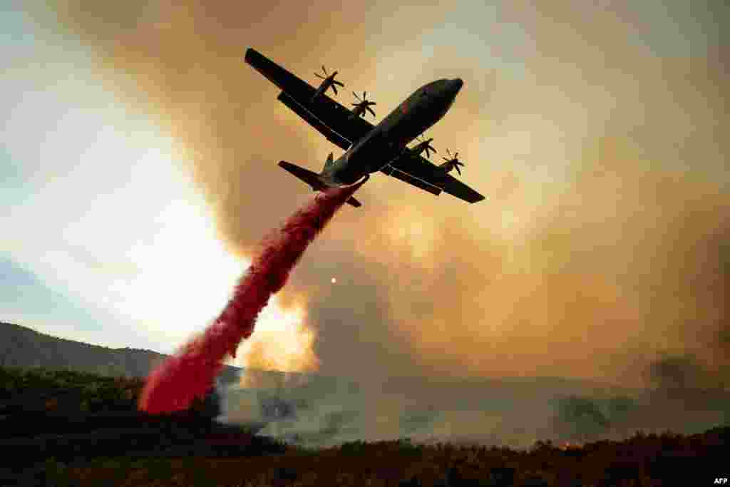 Sebuah pesawat tanker menjatuhkan bahan pemadam kebakaran di atas kebakaran hutan yang melanda komplek Mendocino, High Valley Rd, dekat Clearlake Oaks, California.