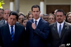 Lawmakers Juan Guaido, center, President of National Assembly, Edgar Zambrano, left, first Vice President and Stalin Gonzalez, right, second Vice President pose after being sworn in during a special session at the National Assembly in Caracas, Venezuela,