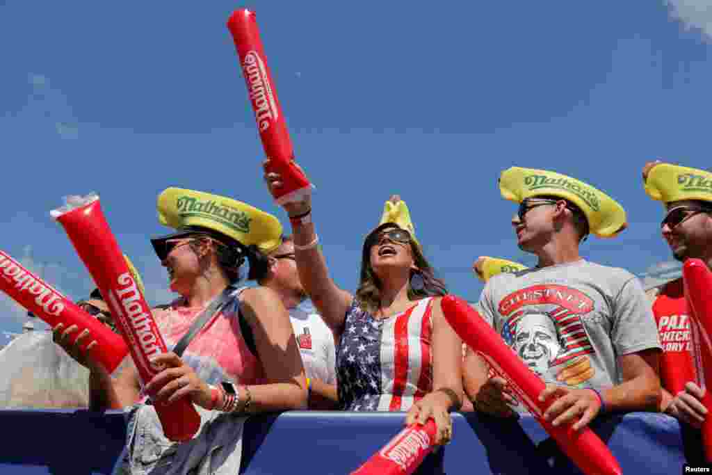 People cheer ahead of the Nathan's Famous Fourth of July Hot Dog-Eating Contest held on Independence Day at Maimonides Park in Brooklyn, New York City.