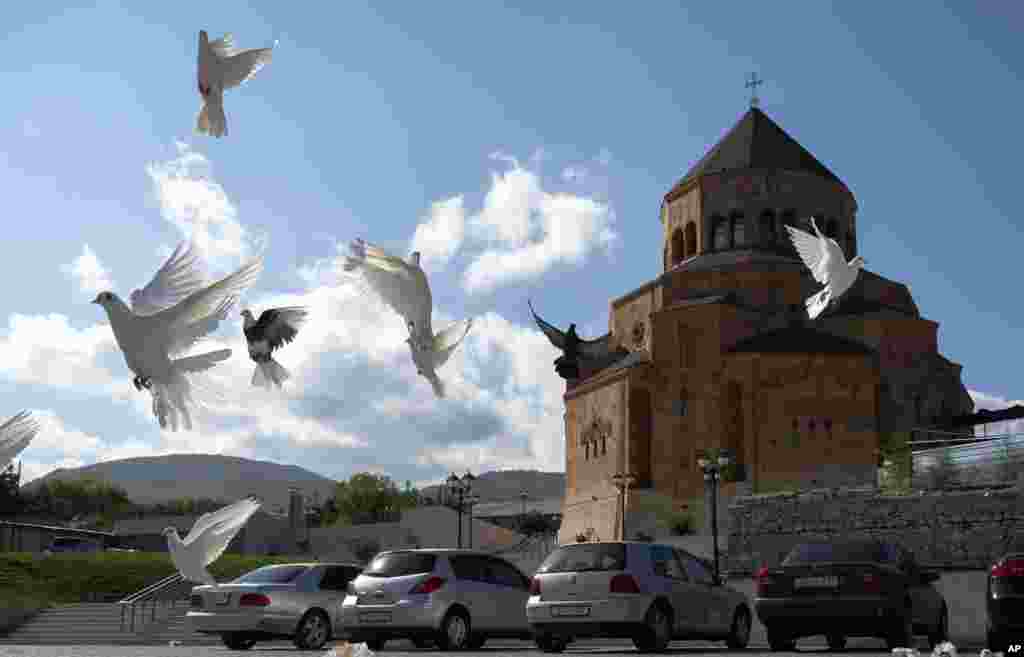 Pigeons fly near Holy Mother of God Cathedral in Stepanakert during a military conflict in the separatist region of Nagorno-Karabakh, Friday, Oct. 9, 2020. The latest outburst of fighting between Azerbaijani and Armenian forces began Sept. 27 and marked t