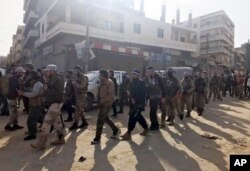 Turkey-backed Free Syrian Army soldiers walk in city center of Afrin, northwestern Syria, March 18, 2018.