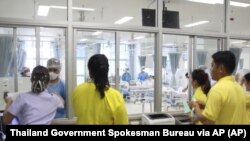 In this photo taken from video released by Thailand government, family members watch the rescued boys through a window at the Chiang Rai hospital in northern Thailand, Wednesday, July 11, 2018.