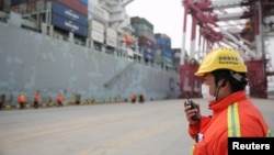 中国山东青岛港的一名戴着口罩的工人在集装箱码头工作。（2020年2月4日）