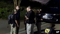 Agents with the Bureau of Alcohol, Tobacco, Firearms and Explosives leave the family home, in Baltimore, Aug. 26, 2018, of the suspect in a mass shooting earlier in the day in Jacksonville, Florida.