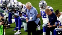 FILE - The Dallas Cowboys, led by owner Jerry Jones, center, take a knee prior to a NFL football game against the Arizona Cardinals, in Glendale, Arizona, Sept. 25, 2017.
