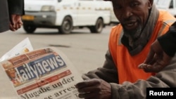 A street vendor reads a newspaper in central Harare, Zimbabwe, Nov. 16,2017.