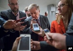 With reporters looking for updates, Sen. Lindsey Graham, R-S.C., a member of the Senate Budget Committee, heads to the chamber to vote on amendments as the Republican leadership works to craft their sweeping tax bill, on Capitol Hill in Washington, Nov. 30, 2017.