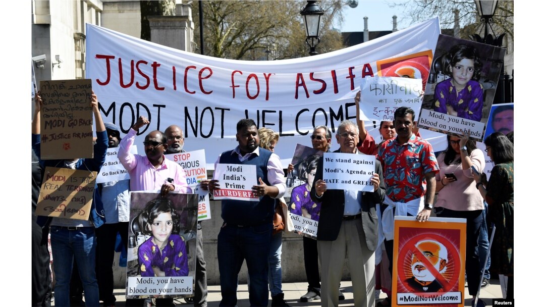 Demonstrators carry placards demanding justice for Asifa, an 8-year-old girl who was raped and murdered in India, during a rally protesting a visit by Indian Prime Minister Narendra Modi, in London, April 18, 2018.