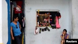 در هاوانا فروشنده ای در انتظار مشتری است تا کالاهای وارداتی خود را بفروشد 