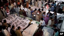 Thân nhân đứng quanh thi hài các nạn nhân bị giết trong vụ tấn công tự sát, Lahore, Pakistan 2/11/14