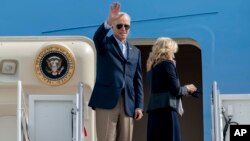 President Joe Biden waves as he and first lady Jill Biden board Air Force One, Oct. 28, 2021, at Andrews Air Force Base, Md.