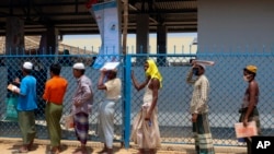 Rohingya refugees stand in line to collect food aid at the Kutupalong refugee camp in Cox's Bazar, Bangladesh. (File)