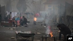 Syrian refugees try to stay warm near open fires in front of their unheated tents in a refugee camp in the town of Harmanli, Bulgaria, Thursday, Nov. 21, 2013. AP Photo/Valentina Petrova