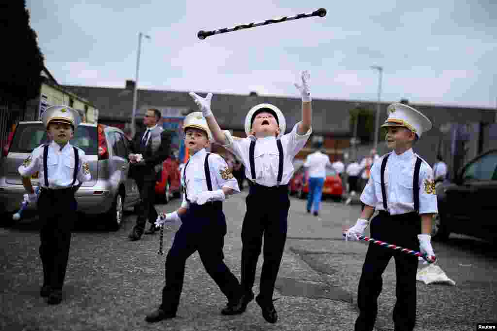 Young members of the Loyalist Order march with their batons as they participate in Twelfth of July celebrations in Belfast, Northern Ireland.