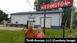 Karen Wingo (L), A Manager of Thrift Avenue store and Buddhist monk Sutham Nateetong (R) pose at the Lexington sign along the U.S Historic Route 66 in Lexington, IL. May 29, 2019.