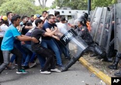 资料照片：委内瑞拉大学生在首都加拉加斯一次反马杜罗政府示威中试图夺走防暴警察的防护盾。(2019年11月14日)