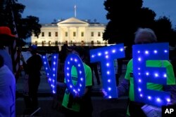 지난 6일 미국 워싱턴이 백악관 앞에서 시민들이 "VOTE(투표하라)" 철자가 적힌 보드를 들고 브렛 캐버노 연방 대법관 지명자 인준 반대 시위에 참가하고 있다.