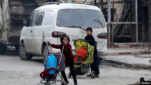 Niños empujan coches con sus pertenencias mientras huyen hacia los últimos enclaves rebeldes de Alepo, en Siria. Dec. 12, 2016.