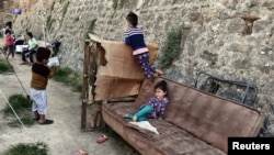 Les enfants jouent dans un camp de la municipalité abritant des migrants et des réfugiés dans la ville de Chios, sur l'île égéenne grecque de Chios, le 28 septembre 2016.