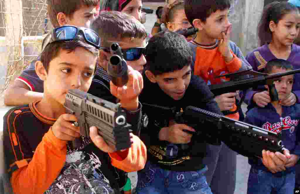 2012年10月27日，在宰牲节假日期间，黎巴嫩南部港口城市西顿的一个叙利亚难民营里的难民儿童玩玩具武器。