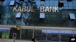 An Afghan girl walks past by Kabul Bank main office in Kabul, Afghanistan. (File Photo)