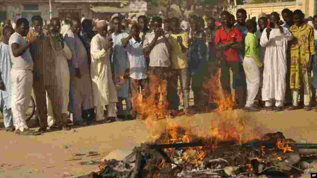 Mutane sun taru su na kallo a inda bam ya tashi a babban Masallacin Jumma'a na Kano, Jumma'a 28 Nuwamba, 2014. Mutane da yawa sun rasa rayukansu, kuma jami'ai suka ce watakila yawan wadanda zasu hallaka zai karu.