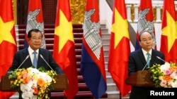 In this photo taken on Dec. 7, 2018, Cambodia's Prime Minister Hun Sen and his Vietnamese counterpart Nguyen Xuan Phuc attend a news conference in Hanoi, Vietnam.