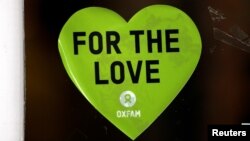 A sticker is seen in the window of a branch of Oxfam, in London, Britain, Feb. 12, 2018. 