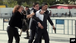 Dilek Dundar, journalist Can Dundar's wife, and his lawyer, second left, overpower a gunman just after the attack on Can Dundar outside the city's main courthouse in Istanbul, May 6, 2016.