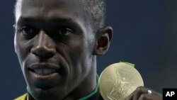 Jamaica's Usain Bolt celebrates with the gold medal after winning the men's 100-meter final during the athletics competitions of the 2016 Summer Olympics at the Olympic stadium in Rio.