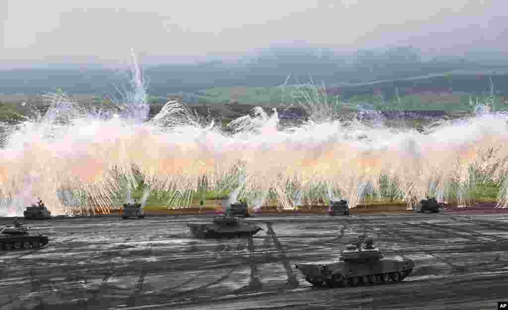 Japan Ground Self-Defense Force&#39;s Type-89 armored combat vehicles flare up a smoke screen during an annual live firing exercise at Higashi Fuji range in Gotemba, southwest of Tokyo.