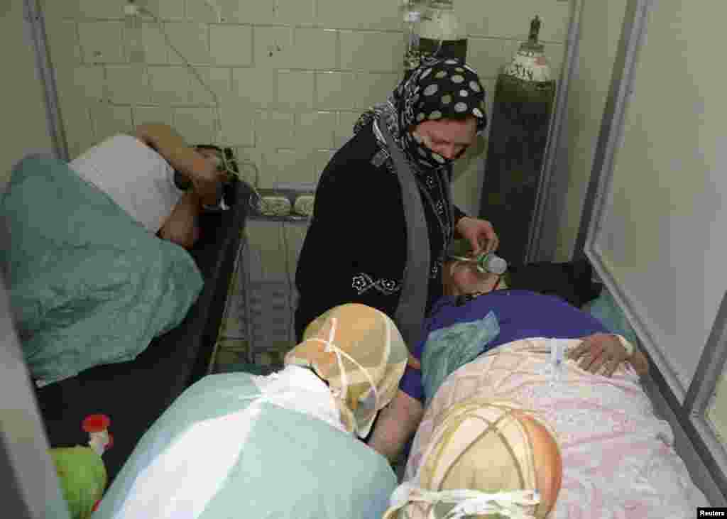 People wounded in what the Syrian government said was a chemical weapons attack breathe through oxygen masks as they are treated at a hospital in Aleppo, March 19, 2013.