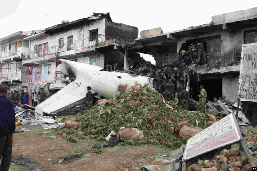 A pile of mild stimulant drug Khat lies beside the wreckage of a Fokker 50 cargo plane after it crashed into a building after takeoff at Kenyatta International Airport, in Nairobi, Kenya.