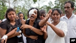 Anusha Kumari, center, weeps during a mass burial for her husband, two children and three siblings, all victims of Easter Sunday's bomb attacks, in Negombo, Sri Lanka, April 24, 2019.