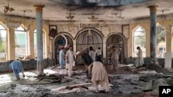 People view the damage inside of a mosque following a bombing in Kunduz, province northern Afghanistan, Oct. 8, 2021.