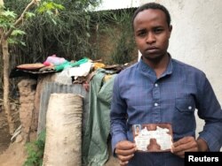 Abedir Jamal holds the identification card of his late brother Obsa Jemal, who was killed in anti-government protests, during a Reuters interview in Harar, Ethiopia, July 22, 2018.