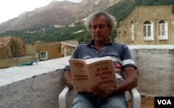 A French man reads Arnaud Cathrine's latest novel, set during the January 2015 terrorist attacks. (L. Bryant/VOA)