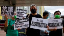 Pro-democracy activist Lee Cheuk-yan, center, holds placards as he arrives at a court in Hong Kong Thursday, April 1,2021. (AP Photo/Vincent Yu)