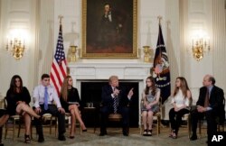 FILE - President Donald Trump speaks as he hosts a listening session with high school students, teachers and parents in the State Dining Room of the White House in Washington, Feb. 21, 2018.