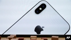 An iPhone X is seen on a large video screen in the new Apple Visitor Center in Cupertino, California, U.S., November 17, 2017. (REUTERS/Elijah Nouvelage)