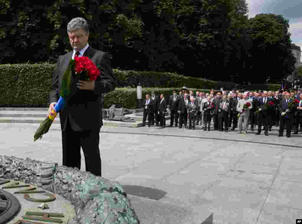 Ukrainian President Petro Poroshenko puts flowers on the Eternal flame dedicated to the Day of Memory and grief, surrounding the events of World War II in Kyiv, June 22, 2014. 